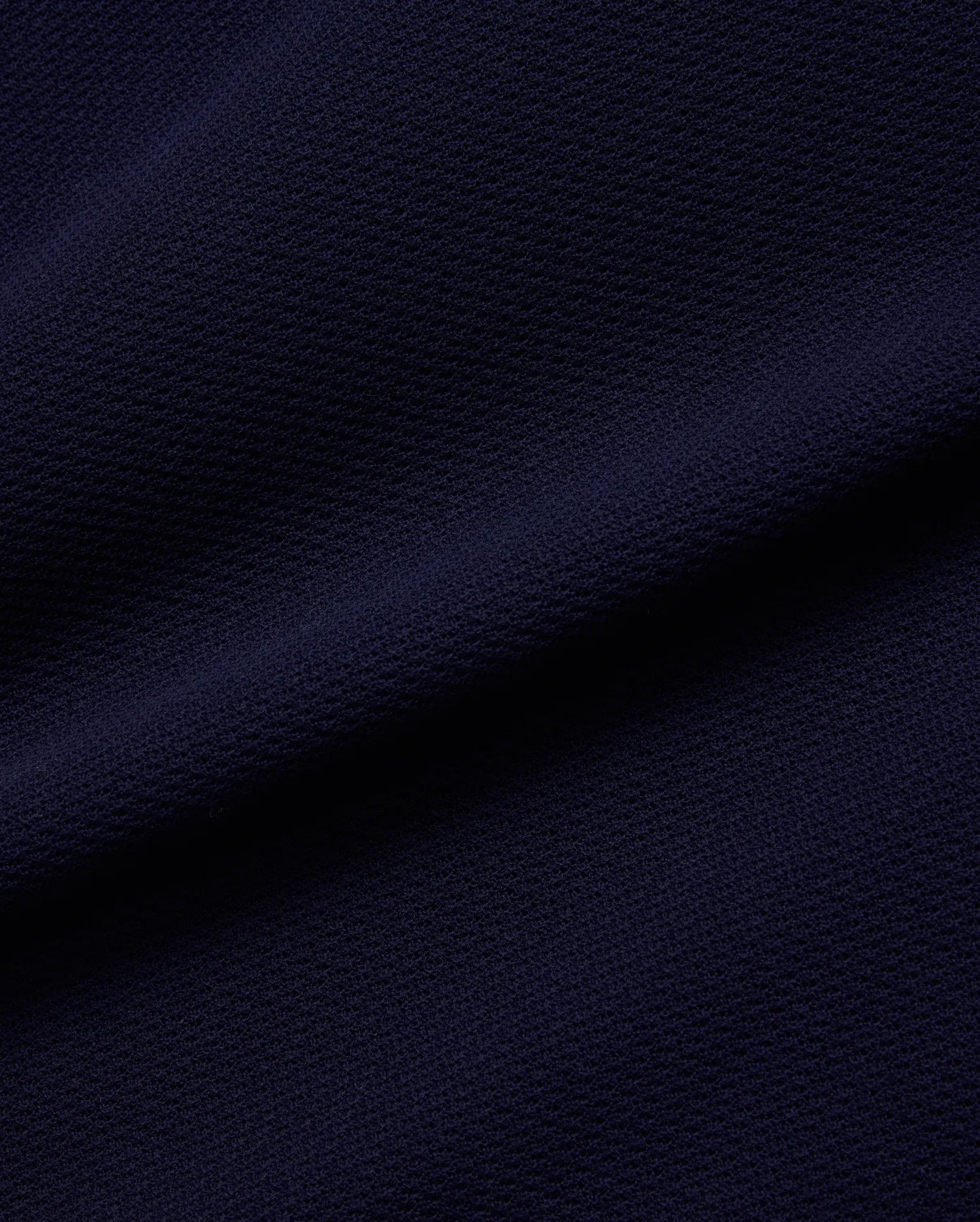 Psycho Bunny Mens Peter Knit Vest fabric in deep navy blue, featuring a premium, subtly textured knit surface, reflecting the brand's refined streetwear aesthetic.
