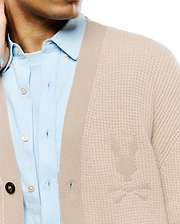 Mens Atkinson Cardigan, a beige textured knit cardigan with a classic fit, featuring a subtle tone-on-tone knitted Psycho Bunny skull logo on the left chest and a ribbed placket.