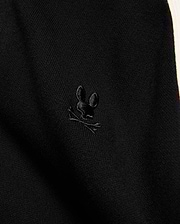 Mens Rafferty Cardigan in black fine knit fabric with a subtle ribbed texture, featuring a small, tonal black embroidered Psycho Bunny skull logo and a cream side stripe.
