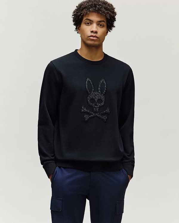 Mens Gabin Textured Crew, a black classic-fit sweatshirt featuring a large, textured Psycho Bunny skull and crossbones logo prominently on the central chest.