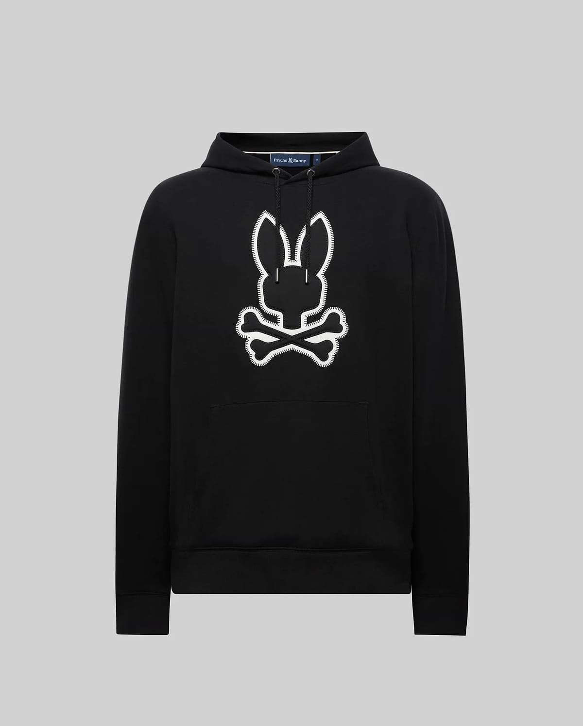 Black Mens Gage Patch Hoodie, relaxed fit, soft cotton blend. Large white embroidered Psycho Bunny skull and crossbones patch with zig-zag stitching on the center chest, plus a front kangaroo pocket.