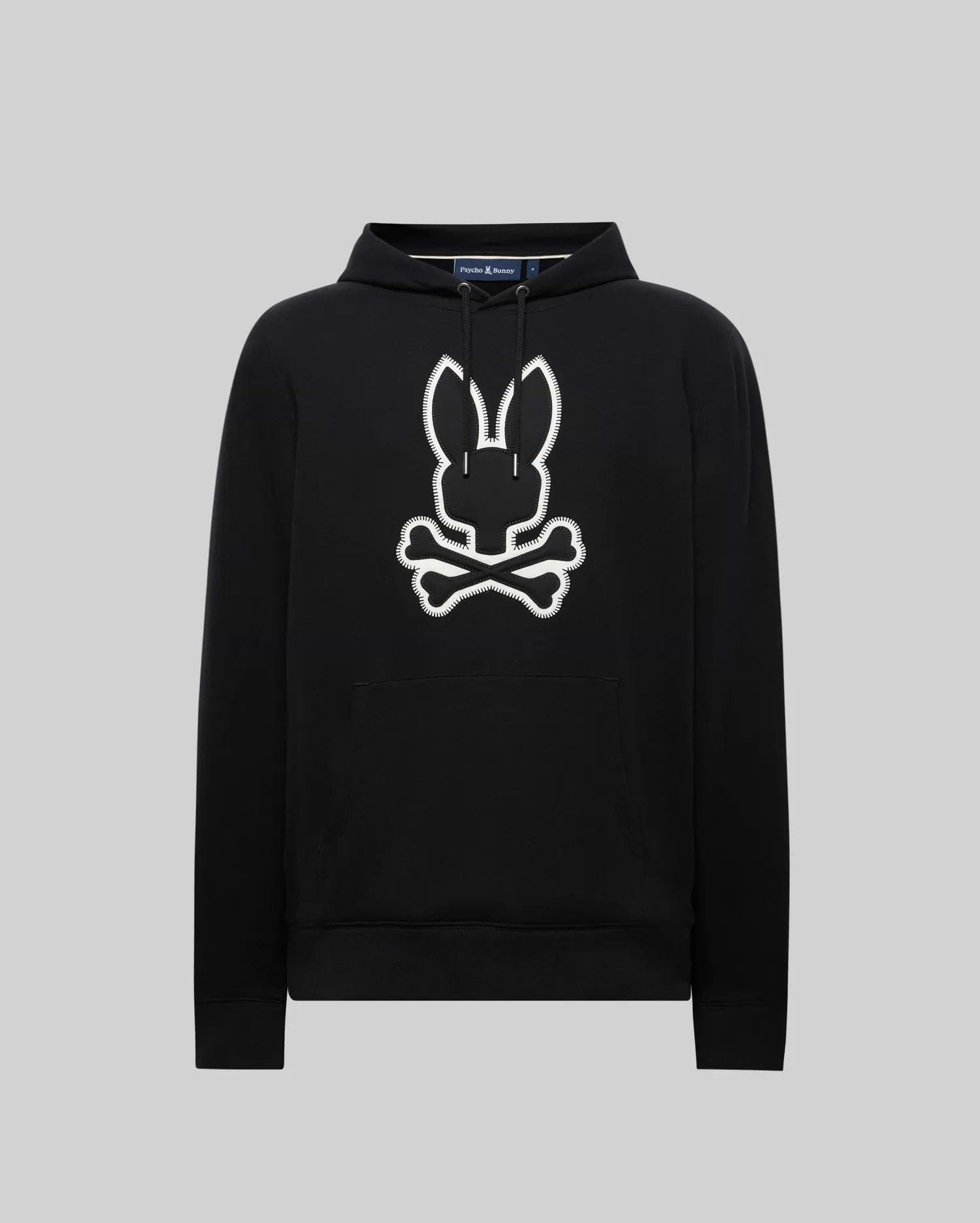 Black Mens Gage Patch Hoodie, relaxed fit, soft cotton blend. Large white embroidered Psycho Bunny skull and crossbones patch with zig-zag stitching on the center chest, plus a front kangaroo pocket.