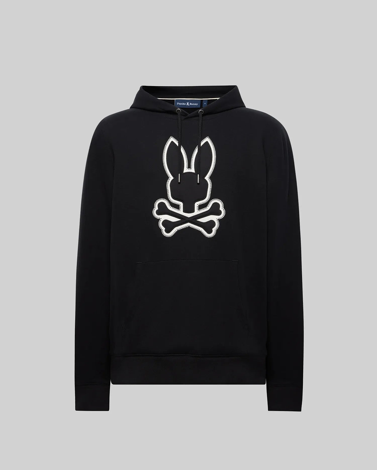 Black Mens Gage Patch Hoodie, relaxed fit, soft cotton blend. Large white embroidered Psycho Bunny skull and crossbones patch with zig-zag stitching on the center chest, plus a front kangaroo pocket.