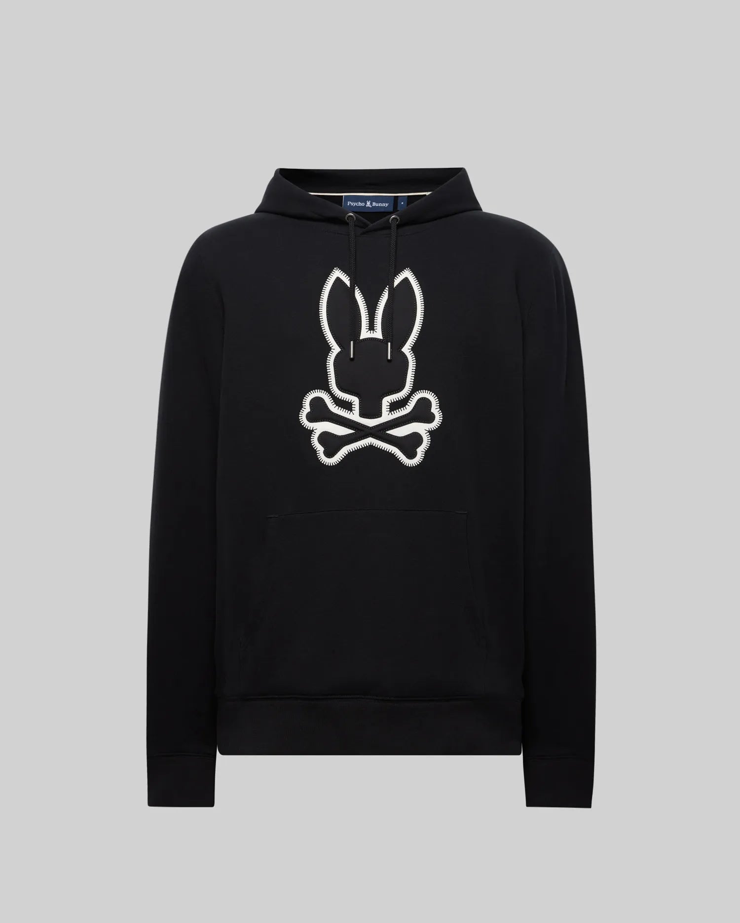 Black Mens Gage Patch Hoodie, relaxed fit, soft cotton blend. Large white embroidered Psycho Bunny skull and crossbones patch with zig-zag stitching on the center chest, plus a front kangaroo pocket.