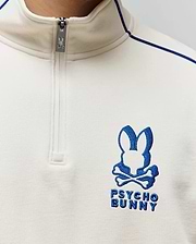 Mens Toby 1/4 Zip in cream smooth knit, featuring a royal blue embroidered Psycho Bunny skull logo on the left chest, blue piping detail, and a branded zipper pull.