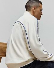 Mens Toby 1/4 Zip in cream, a relaxed fit French terry top with bold blue piping accenting the shoulders and sides. Psycho Bunny branding not visible.