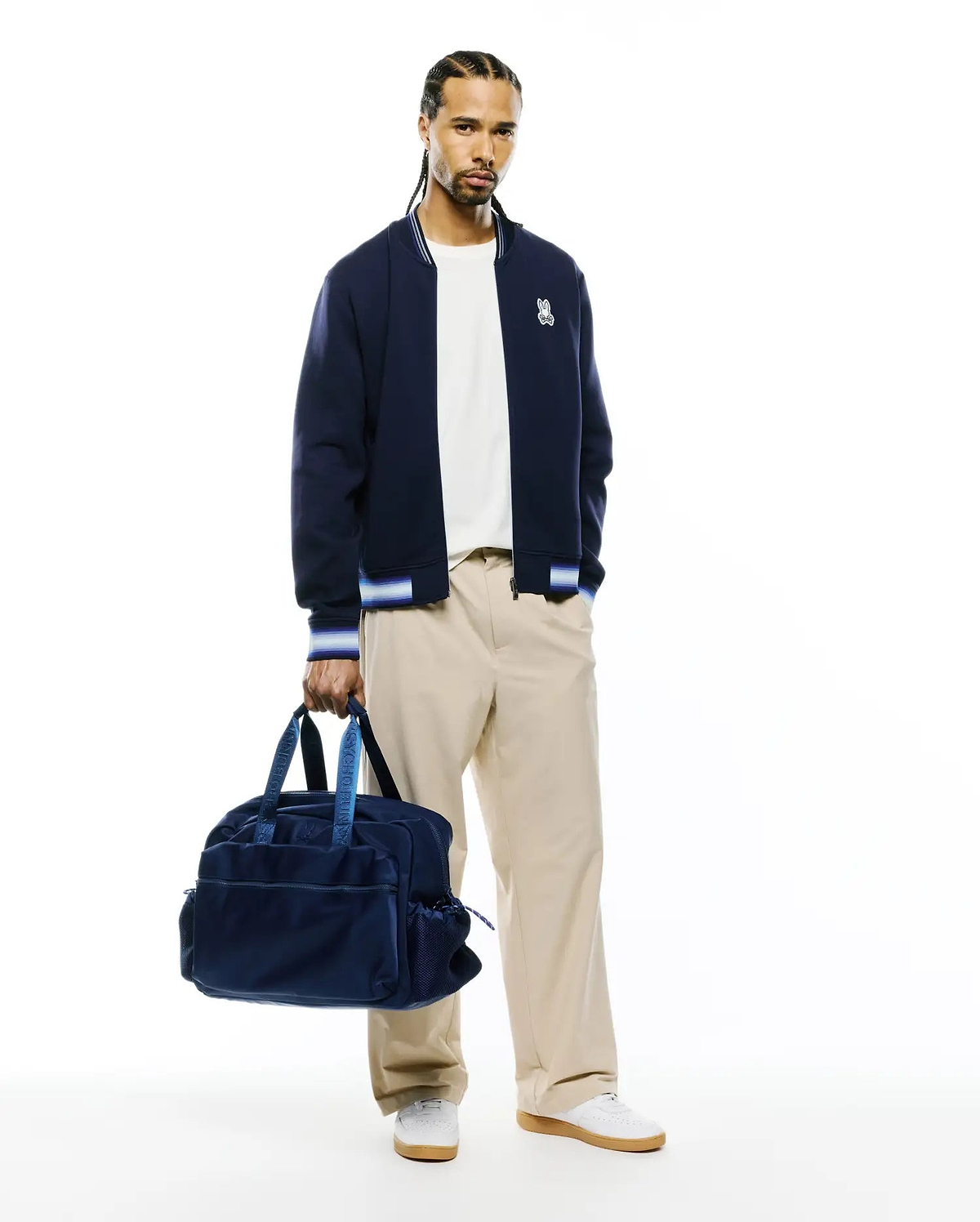 Mens Jaydon Track Jacket, navy blue with white and blue striped ribbed collar, cuffs, and hem. Features a small embroidered white Psycho Bunny skull logo on the left chest. Classic fit, smooth knit fabric. (4)