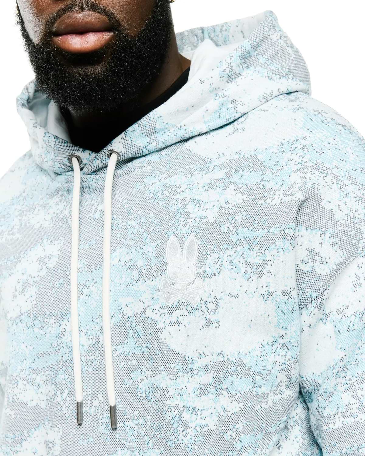 Men's Alfie All-Over Print Hoodie in light blue, white, and grey pixelated digital camo print, featuring a classic fit, soft knit fabric, and an embroidered white Psycho Bunny skull logo on the left chest with white drawstrings. (3)