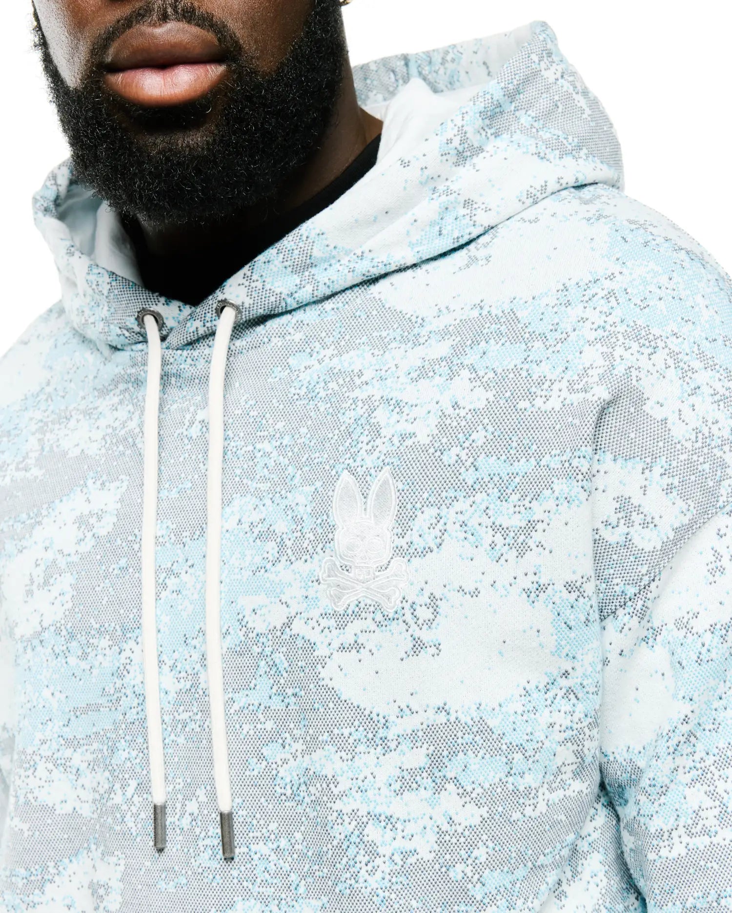 Men's Alfie All-Over Print Hoodie in light blue, white, and grey pixelated digital camo print, featuring a classic fit, soft knit fabric, and an embroidered white Psycho Bunny skull logo on the left chest with white drawstrings. (3)