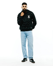 Mens Malcom Splatter Hoodie, a black relaxed fit French terry hoodie featuring an all-over white and teal splatter print and a small embroidered white Psycho Bunny skull logo on the left chest.