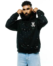 Mens Malcom Splatter Hoodie, a black relaxed fit soft jersey hoodie featuring a vibrant white and teal splatter print and a large white Psycho Bunny skull logo on the left chest.