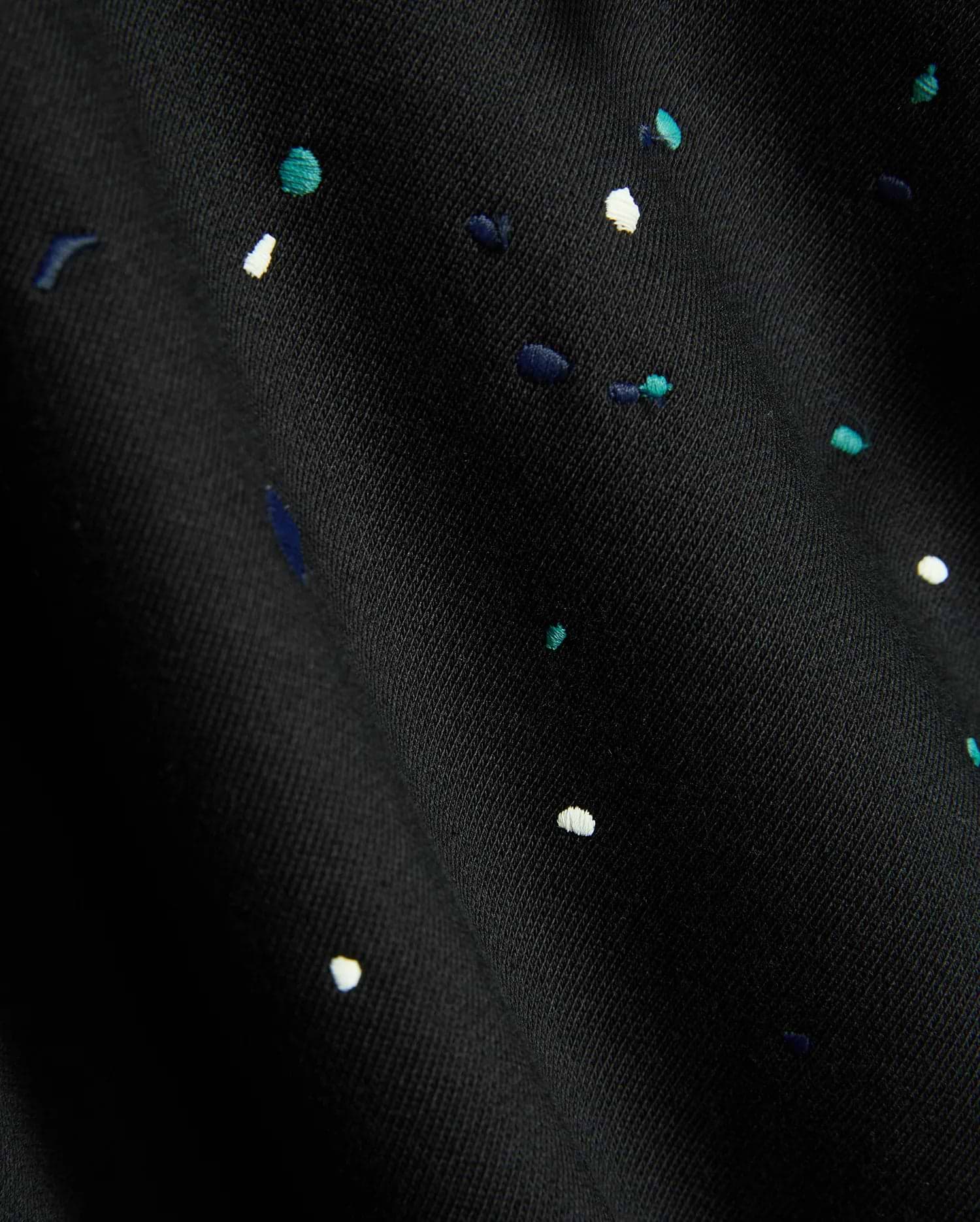 Mens Malcom Splatter Hoodie in black, featuring a soft knit fabric with an embroidered multi-color splatter pattern in white, teal, and dark blue.