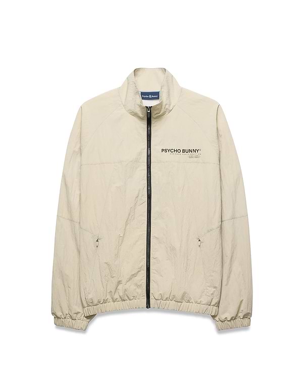 Light beige Mens Alder Nylon Jacket, a classic fit crinkled nylon jacket with full black zip, stand collar, zippered side pockets, elastic cuffs/hem, and a black Psycho Bunny chest logo.