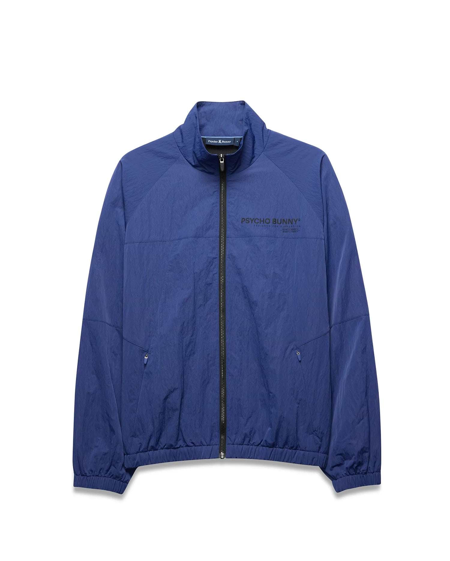 Mens Alder Nylon Jacket, a royal blue full-zip jacket with a crinkled texture, features a stand collar, elastic cuffs/hem, zippered pockets, and a large black PSYCHO BUNNY® DESIGNED FOR DISRUPTION text logo on the chest. (5)