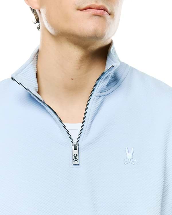 Mens Marc Textured 1/4 Zip, light blue waffle knit, with a silver zipper featuring a Psycho Bunny logo pull and an embroidered white bunny skull logo on the left chest.