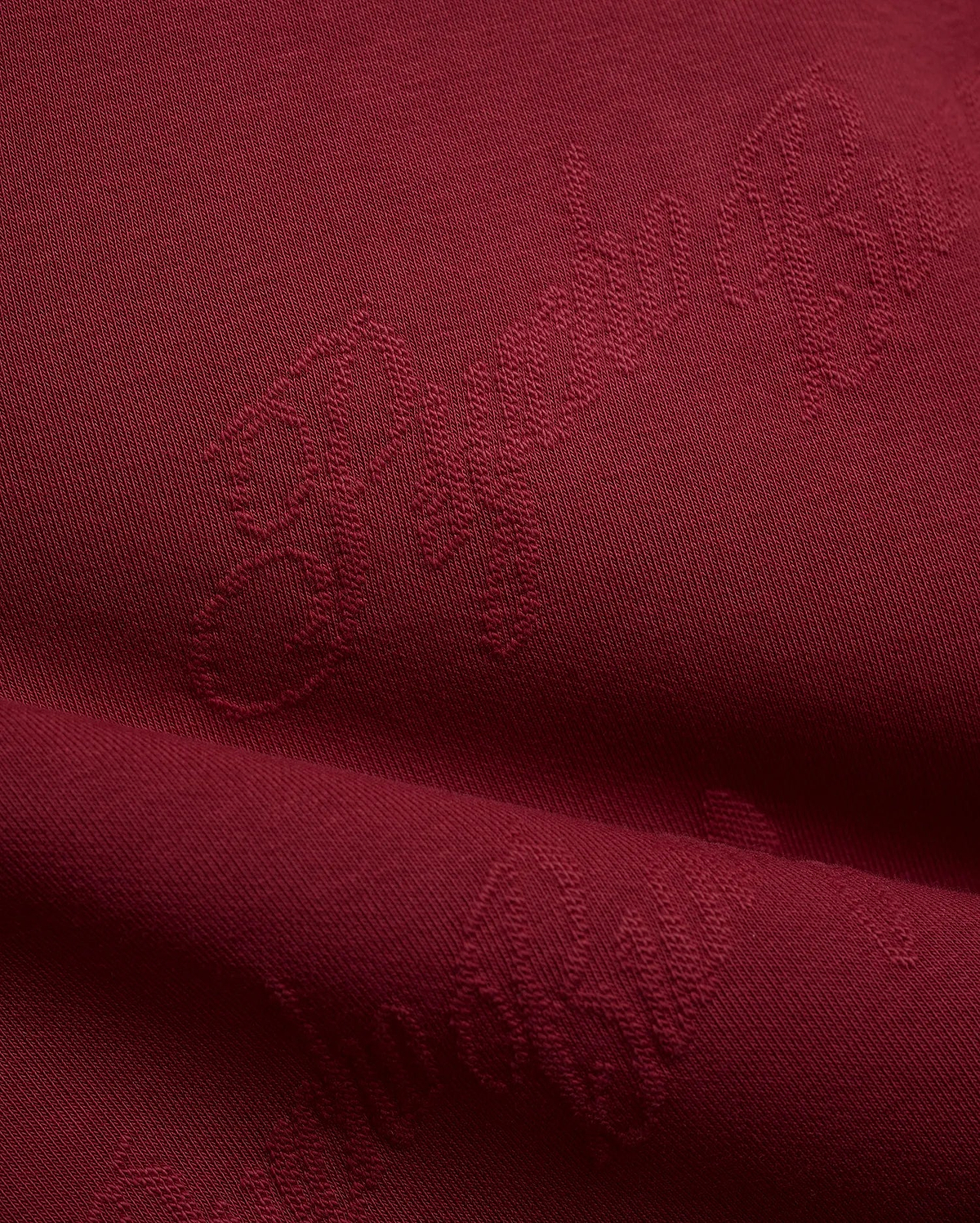 Mens Cedrick All Over Jacquard Crew in deep burgundy, featuring a subtle tone-on-tone jacquard knit pattern of the Psycho Bunny logo and brand name.