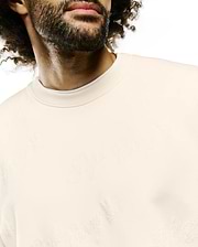 Cream Mens Cedrick All Over Jacquard Crew, a relaxed fit sweatshirt with a subtle tone-on-tone jacquard knit featuring the iconic Psycho Bunny skull logo and brand text throughout.