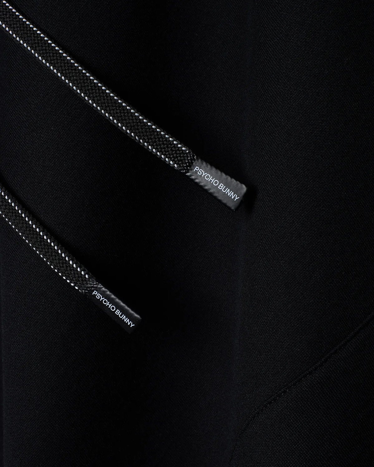 Mens Terrence Fleece Hoodie, black with soft fleece texture, featuring black drawstrings with white dotted accents and Psycho Bunny branded aglets.