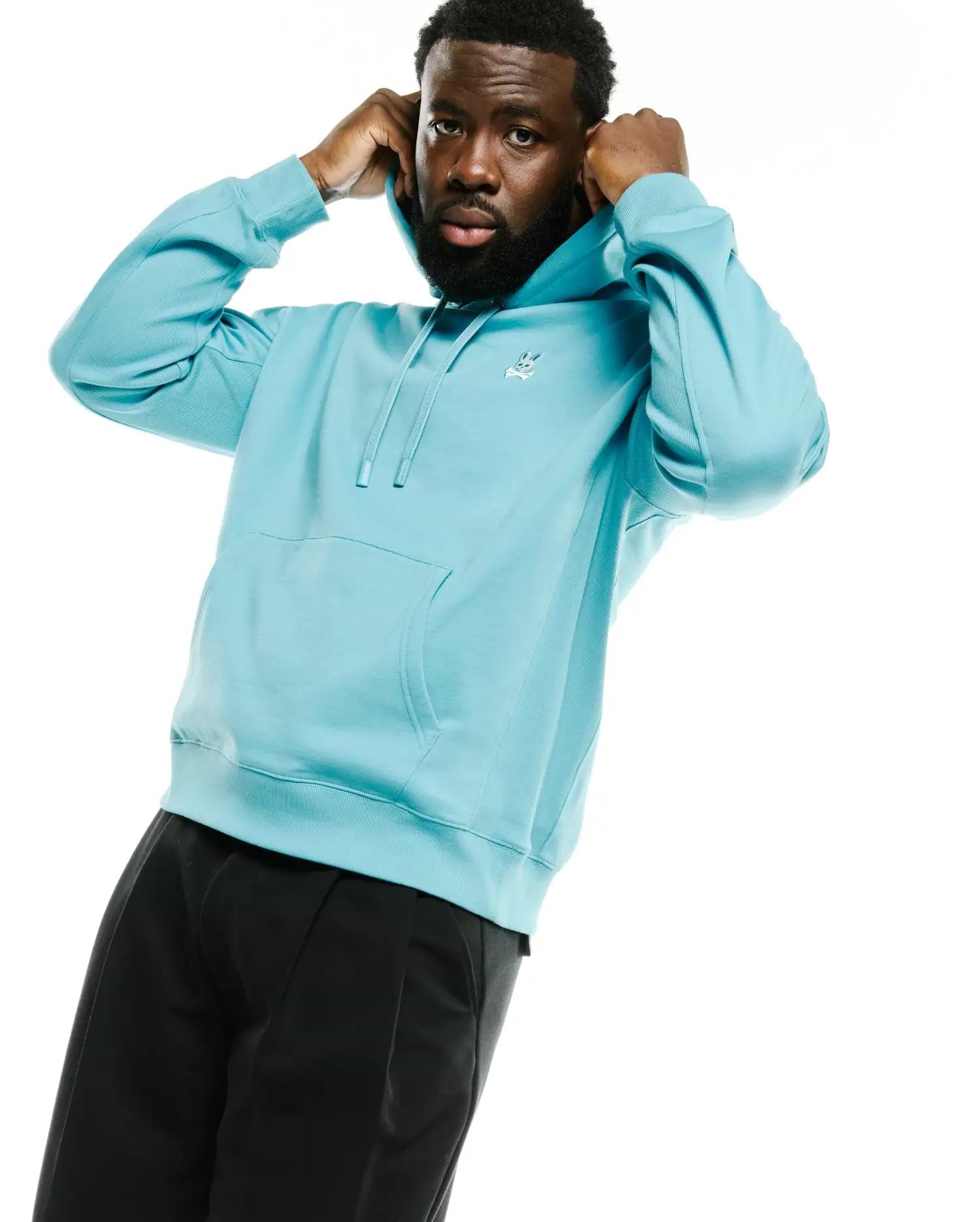Men's Terrence Fleece Hoodie in light blue, featuring a relaxed fit, soft french terry fabric, ribbed cuffs and hem, kangaroo pocket, and a small embroidered white Psycho Bunny skull logo on the left chest. (3)
