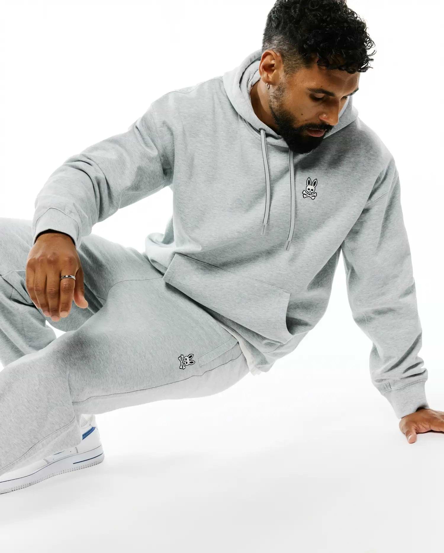 Mens Terrence Fleece Hoodie in heather grey, a relaxed fit fleece hoodie with a drawstring hood, kangaroo pocket, and a small embroidered Psycho Bunny skull logo on the left chest.