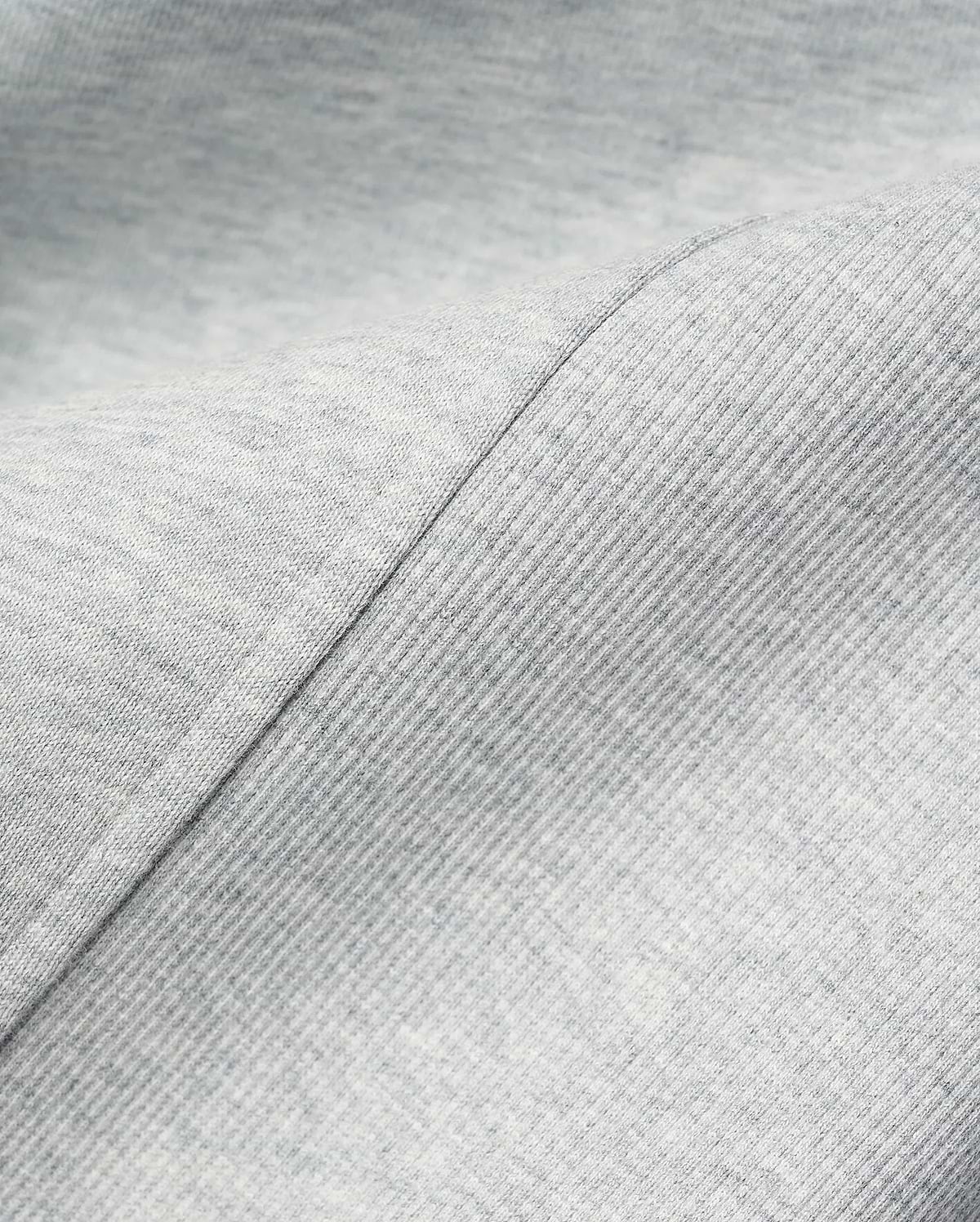 MENS TERRENCE FLEECE HOODIE in light grey heather, showcasing a soft, heathered fleece fabric with a distinct diagonal seam separating it from a finely ribbed texture, emphasizing comfort.