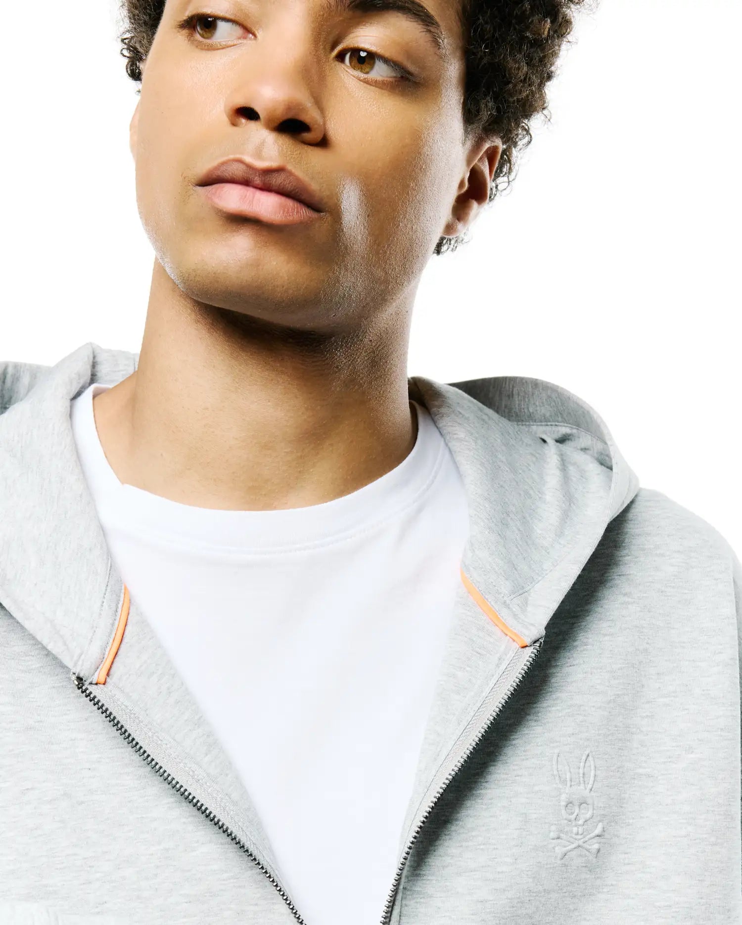 Mens Jonathan Zip Hoodie, heather grey French terry, featuring a full zip, subtle orange inner placket trim, and a tonal embroidered Psycho Bunny skull logo on the left chest. (3)