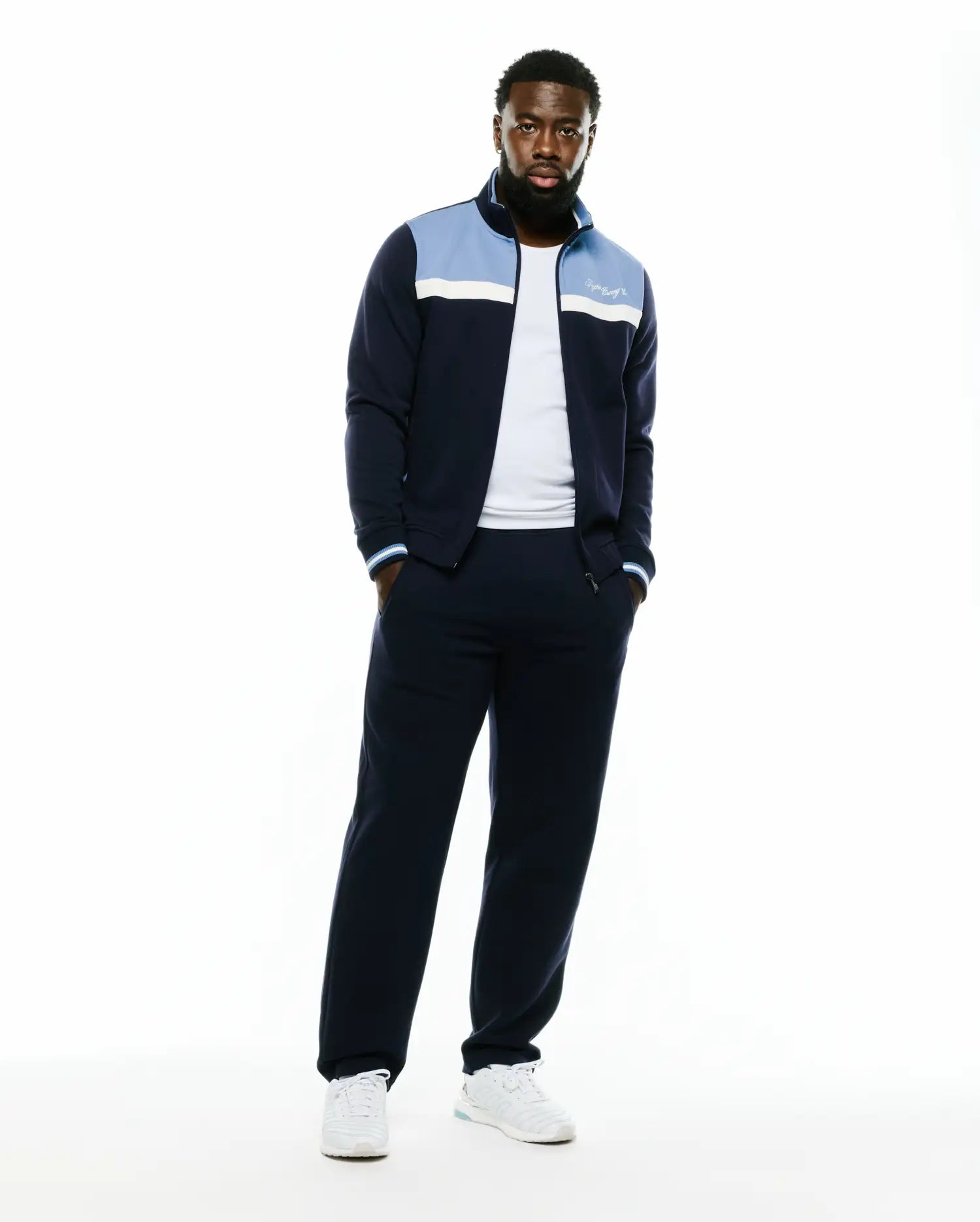 Men's Jacques Pique Track Jacket in navy, featuring a classic fit, light blue and white color-block chest panels, a white embroidered Psycho Bunny script logo on the left chest, and striped ribbed cuffs. (1)