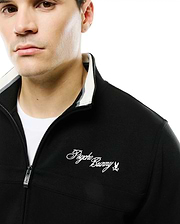 Men's Jacques Pique Track Jacket, black, classic fit, with white and grey striped ribbed collar, full zip with Psycho Bunny skull pull, and embroidered white script logo on left chest. (3)