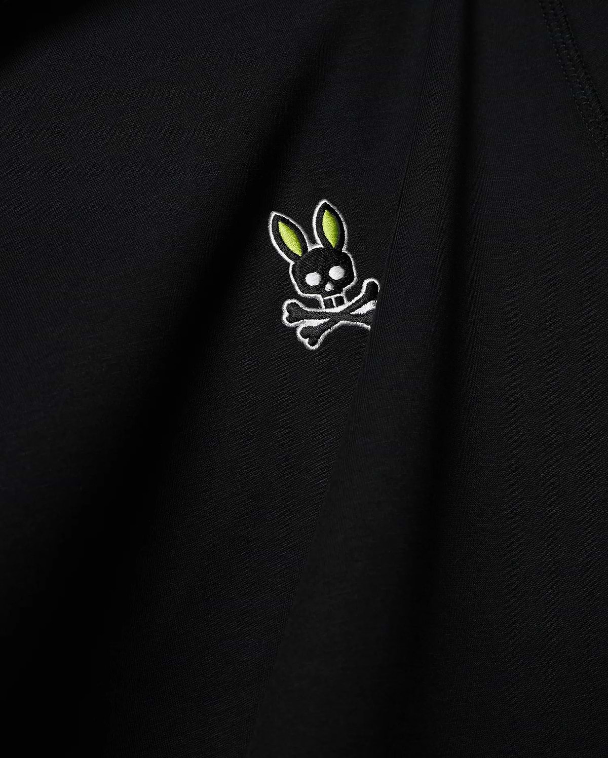 Mens Lex Hoodie, black smooth knit, featuring a small embroidered Psycho Bunny skull logo on the chest with vibrant neon green ears, black skull, and white outline details. (6)