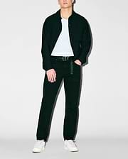 Black collared shirt jacket with small embroidered Psycho Bunny logo on left chest, over white jersey tee, dark Mens Emerson Denim Pant with branded keychain, and white sneakers.