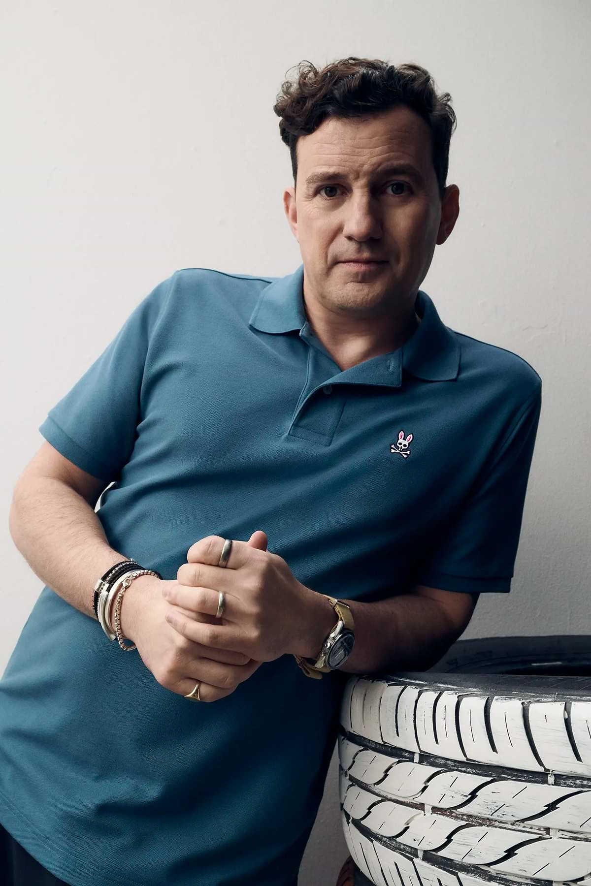 Mens Classic Pique Polo in teal blue, featuring a classic fit and visible pique knit texture. Small embroidered pink, white, and black Psycho Bunny skull logo on the left chest.