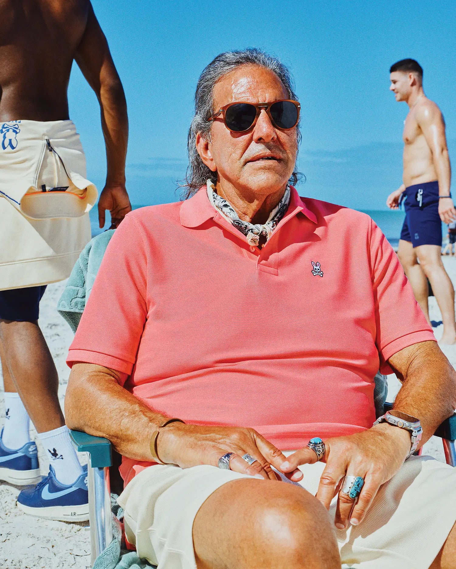 Mens Classic Pique Polo in vibrant coral pink, featuring a classic fit and visible pique texture. A small, embroidered white Psycho Bunny skull logo is on the left chest.