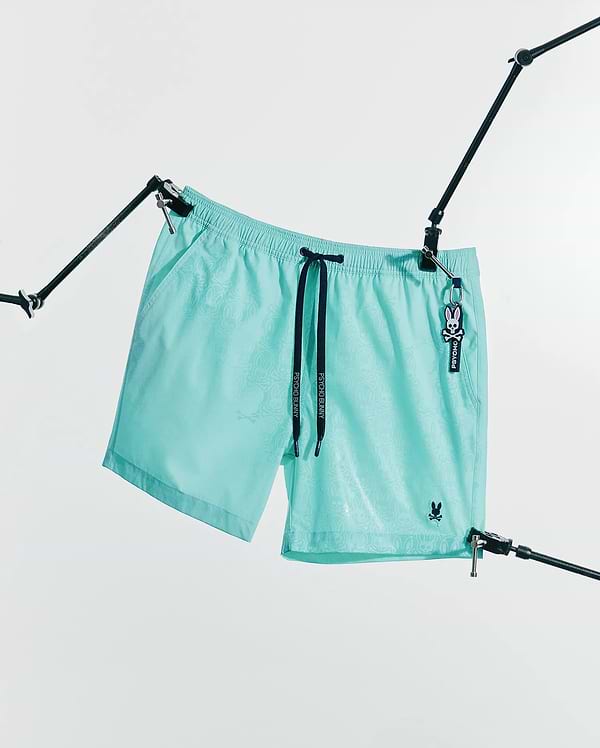 Mens Samos Hydrochromic Printed Swim Trunk 6 in aqua with a subtle hydrochromic bunny skull pattern, black Psycho Bunny drawstrings, and a small embroidered bunny skull logo.