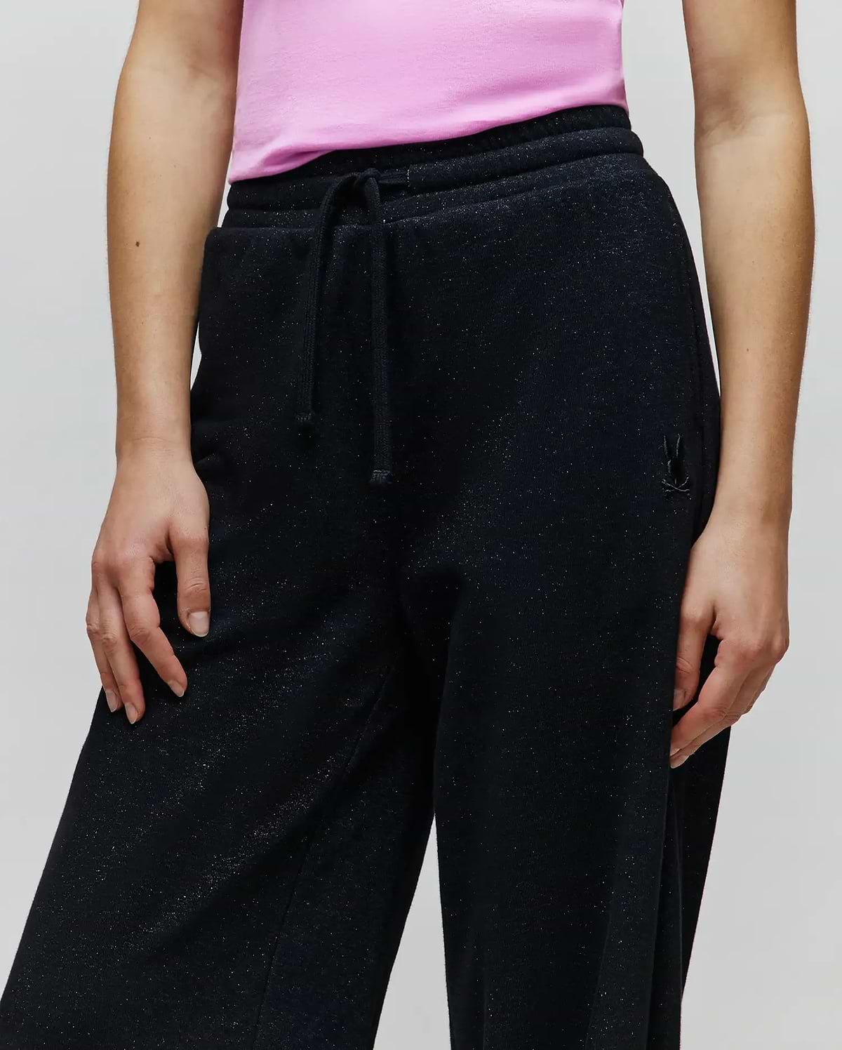 Womens Jules Lurex Sweatpant, black relaxed fit with subtle silver lurex sparkle, featuring a drawstring waist and a small tonal embroidered Psycho Bunny skull logo on the right hip.