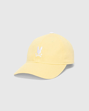WOMEN'S AMARIS BASEBALL CAP in pastel yellow cotton twill, featuring a prominent white embroidered Psycho Bunny skull logo centered on the front, with a classic relaxed fit.