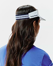 Women's Sport Visor featuring a crisp white brim, a navy blue elastic band with prominent light blue and white stripes, and an embroidered Psycho Bunny text logo on the front panel. (3)