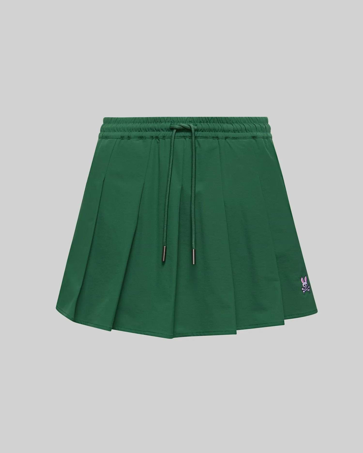 WOMEN'S CECILIA PLEATED SKORT in dark green, featuring an elastic drawstring waist, a relaxed A-line fit with crisp pleats, and a small embroidered pink Psycho Bunny skull logo on the lower right hem. (5)