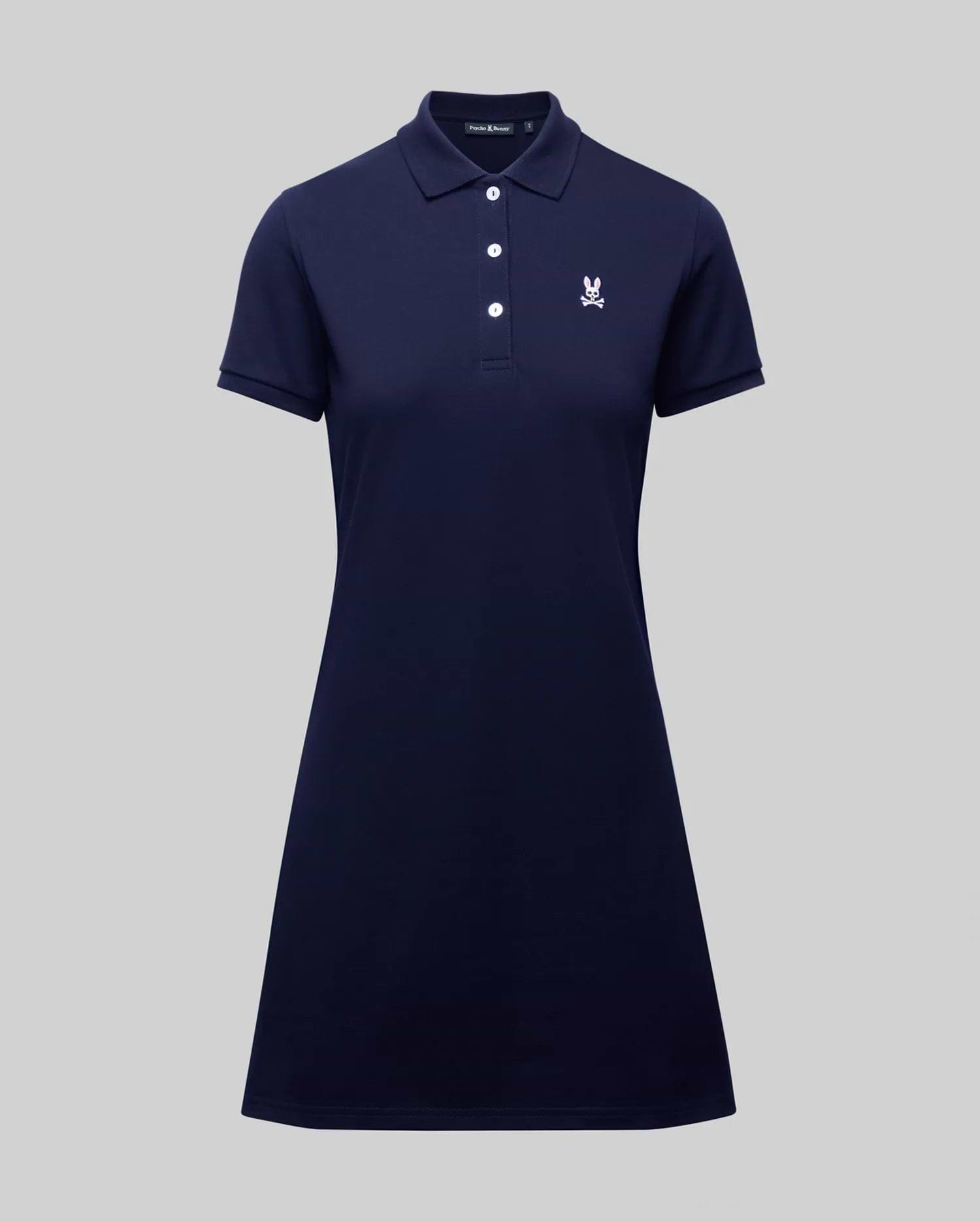 The WOMENS POLO DRESS - WO2000003 by Psycho Bunny is a navy blue, short-sleeve 100% Pima cotton polo dress with a collar, four buttons, white embroidered crest on the chest, and feminine fit. Shown on a plain gray background.