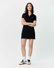 Women's Clara Pique Dress, a classic fit black pique mini dress featuring a polo collar, V-neck, short sleeves, and a small white embroidered Psycho Bunny skull logo on the left chest.