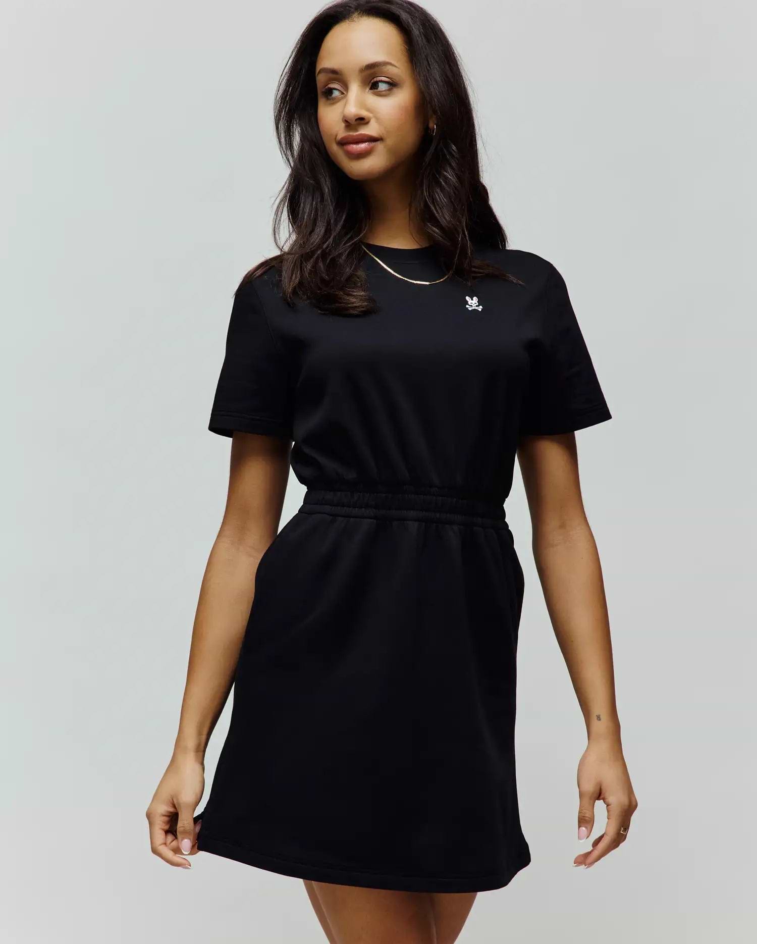 Womens Penelope Dress: Black short-sleeve jersey dress with a relaxed fit, crew neck, elasticated waist, side pockets, and a small embroidered white Psycho Bunny skull logo on the left chest.