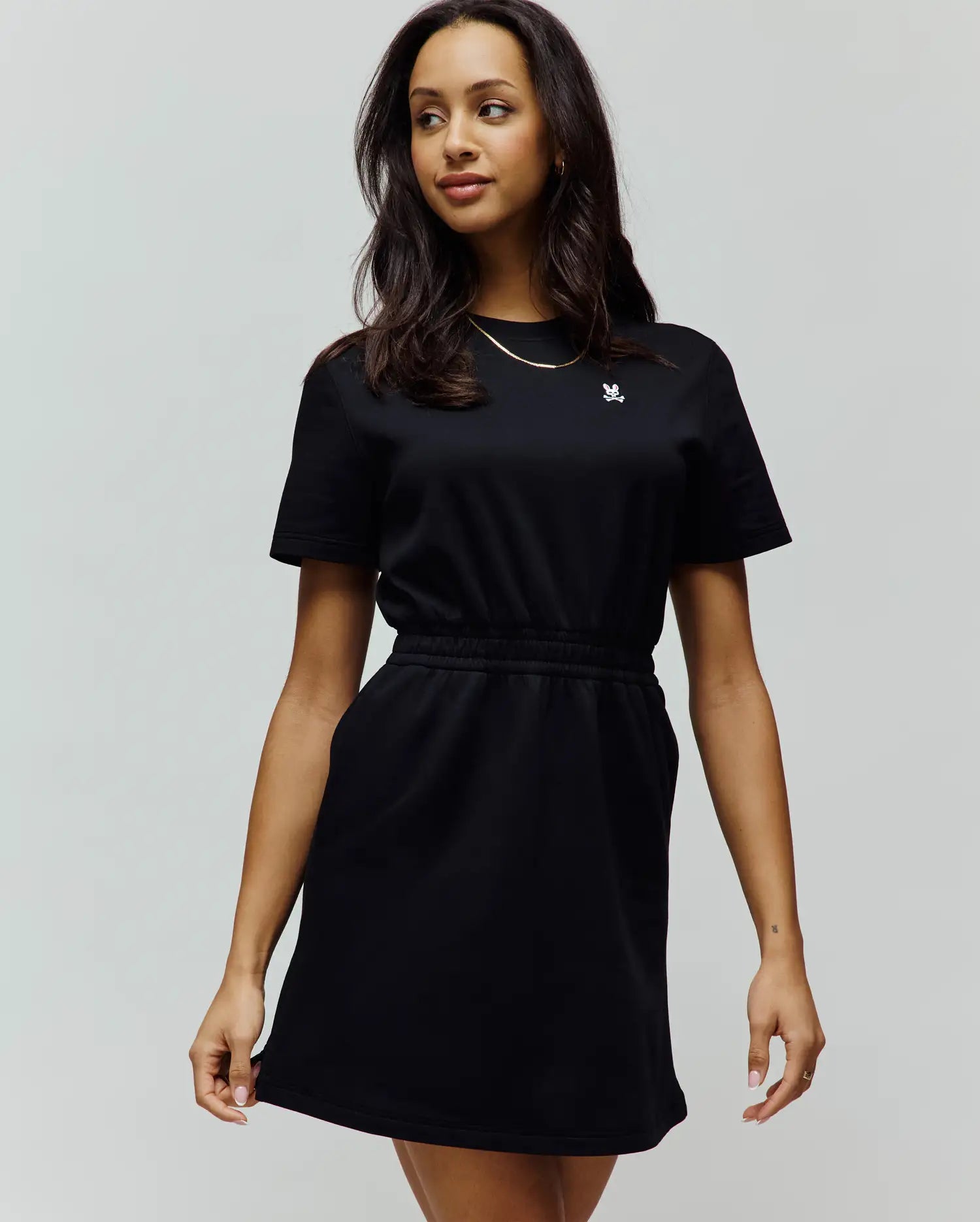 Womens Penelope Dress: Black short-sleeve jersey dress with a relaxed fit, crew neck, elasticated waist, side pockets, and a small embroidered white Psycho Bunny skull logo on the left chest.