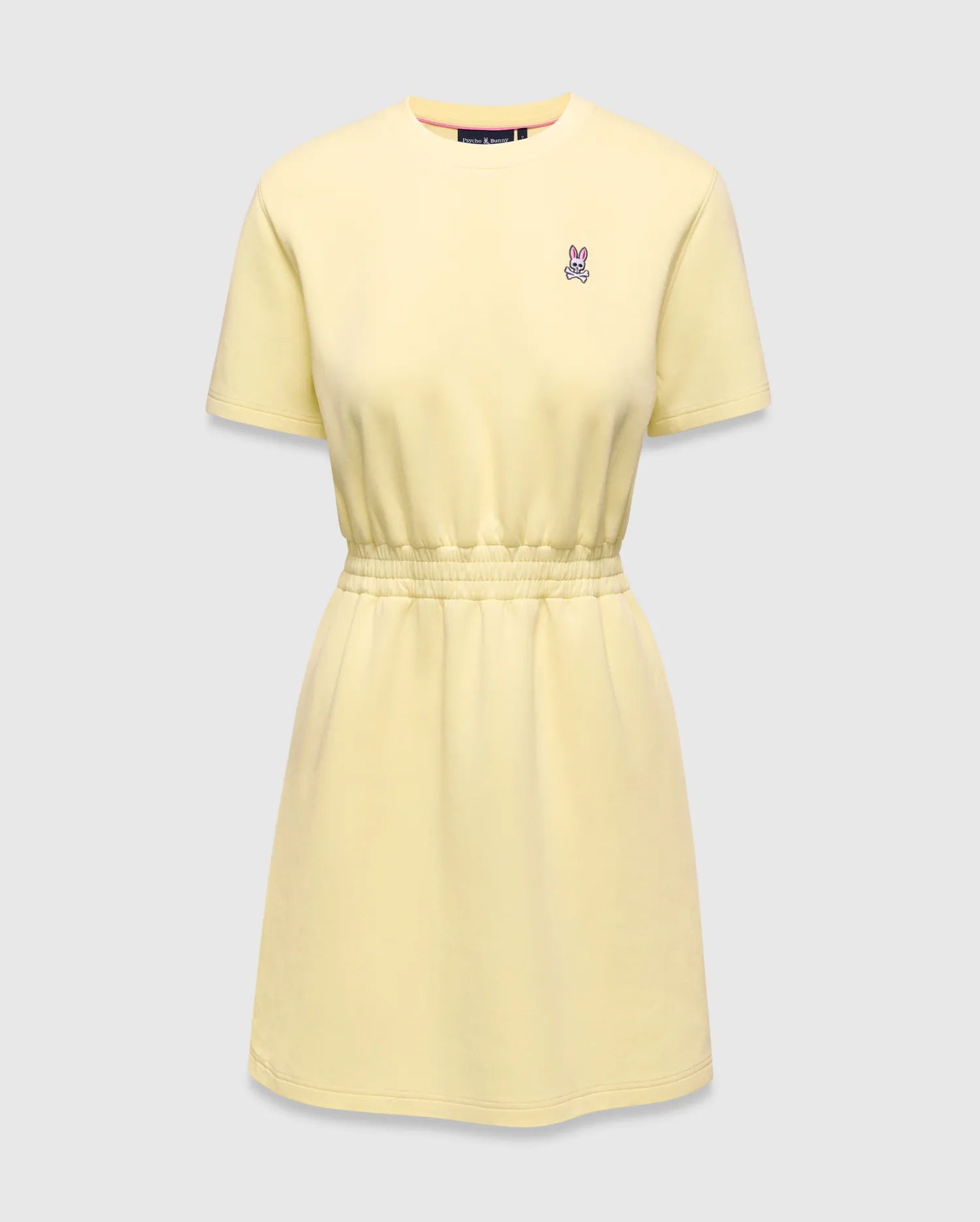 Womens Penelope Dress, a light yellow jersey knit dress with a relaxed fit, crew neck, short sleeves, and an elasticated waist. Features a small pink and white embroidered Psycho Bunny skull logo on the left chest.
