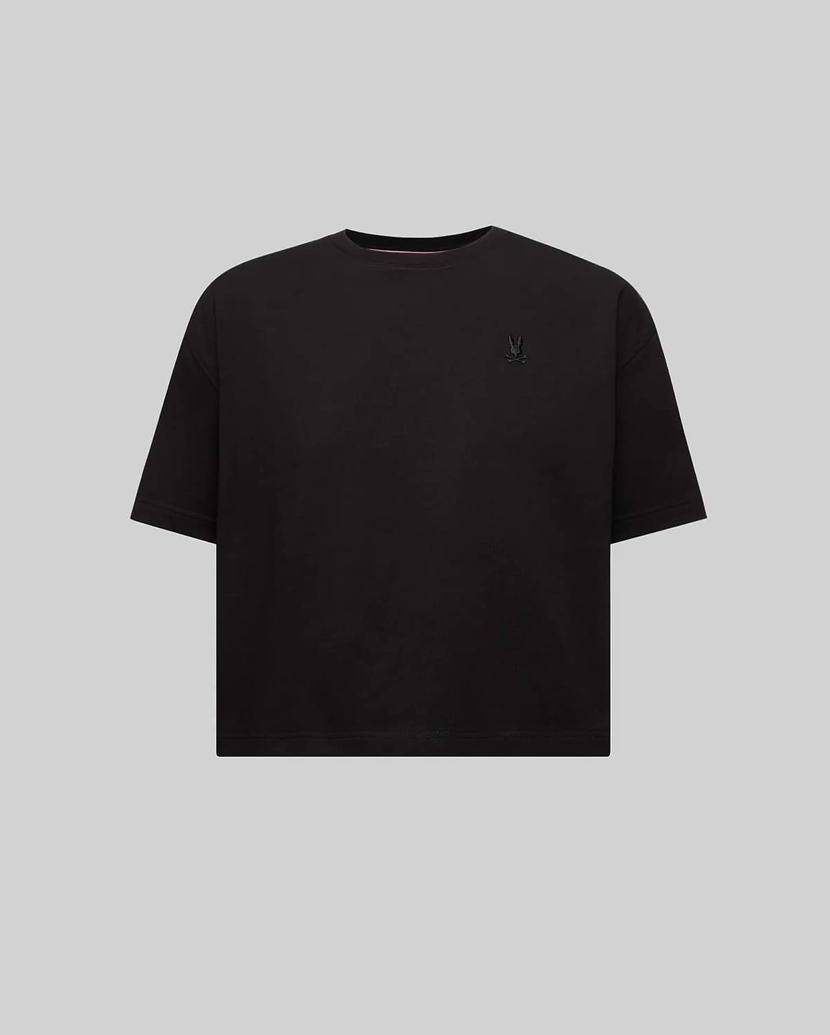 Women's Camille Oversized Fit Tee, a black oversized jersey knit t-shirt featuring a small embroidered black Psycho Bunny skull logo on the left chest and pink neck tape.