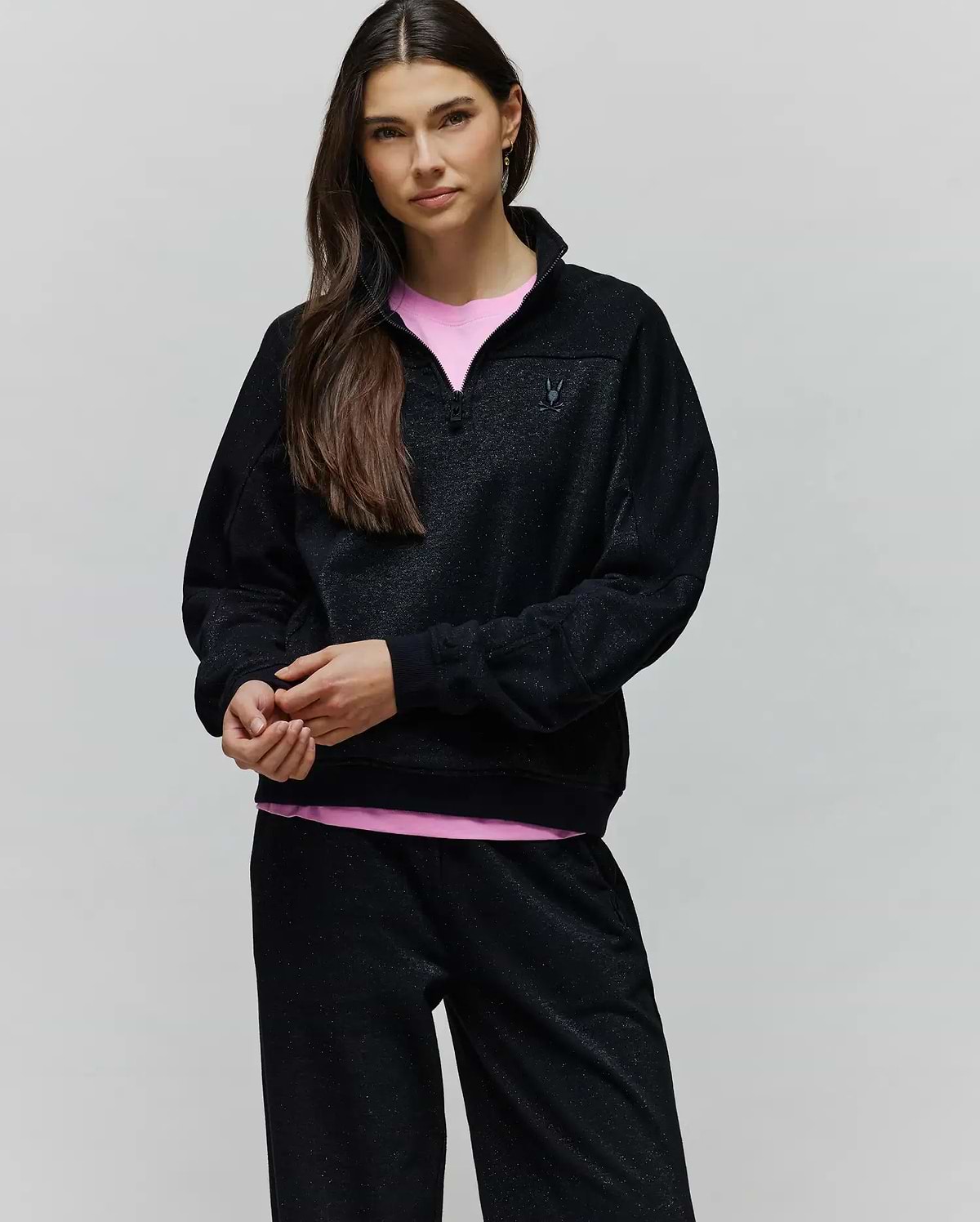 Womens Jules Lurex 1/4 Zip Pullover, a relaxed fit black lurex knit with subtle silver sparkle, featuring a stand collar, 1/4 zip closure, and a small embroidered black Psycho Bunny skull logo on the left chest.