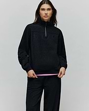 Womens Jules Lurex 1/4 Zip Pullover in black lurex knit with subtle silver sparkle, featuring a relaxed fit, high collar, 1/4 zip, and small embroidered black Psycho Bunny skull logo on the left chest.