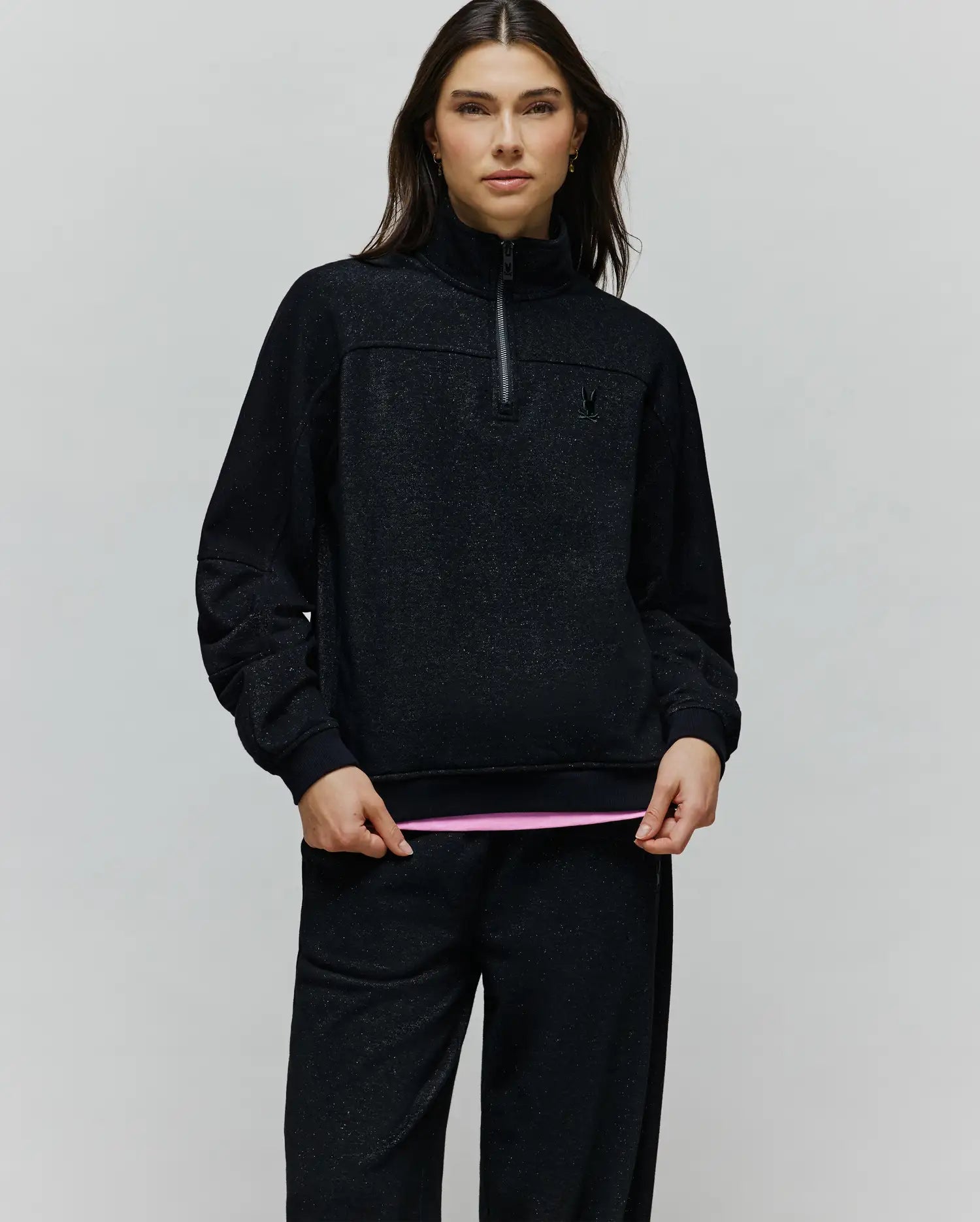 Womens Jules Lurex 1/4 Zip Pullover in black lurex knit with subtle silver sparkle, featuring a relaxed fit, high collar, 1/4 zip, and small embroidered black Psycho Bunny skull logo on the left chest.