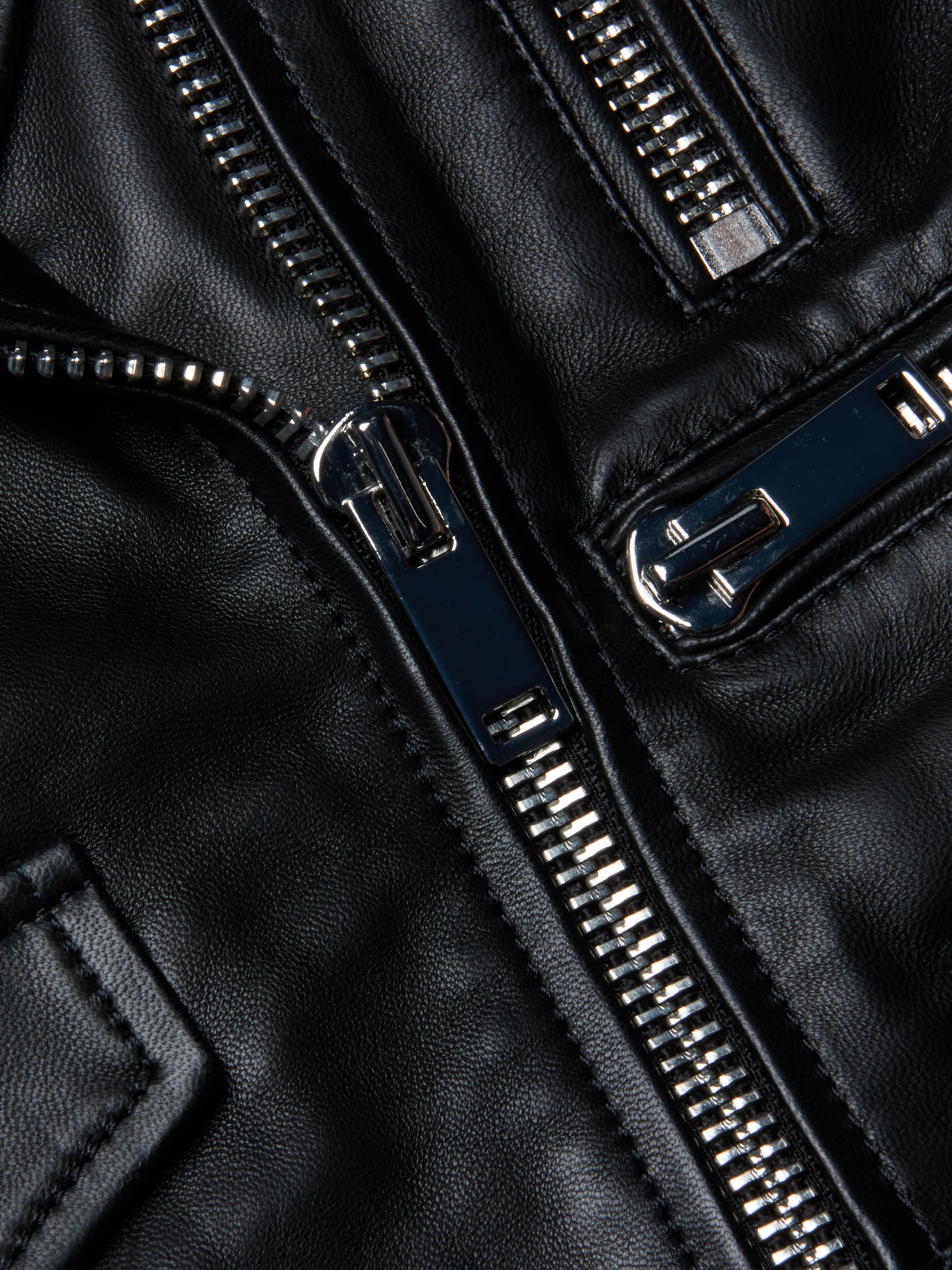 Close-up of shiny silver zippers on the Blakely Leather Biker Jacket, crafted from black lambskin leather, highlighting the texture and detailed stitching.