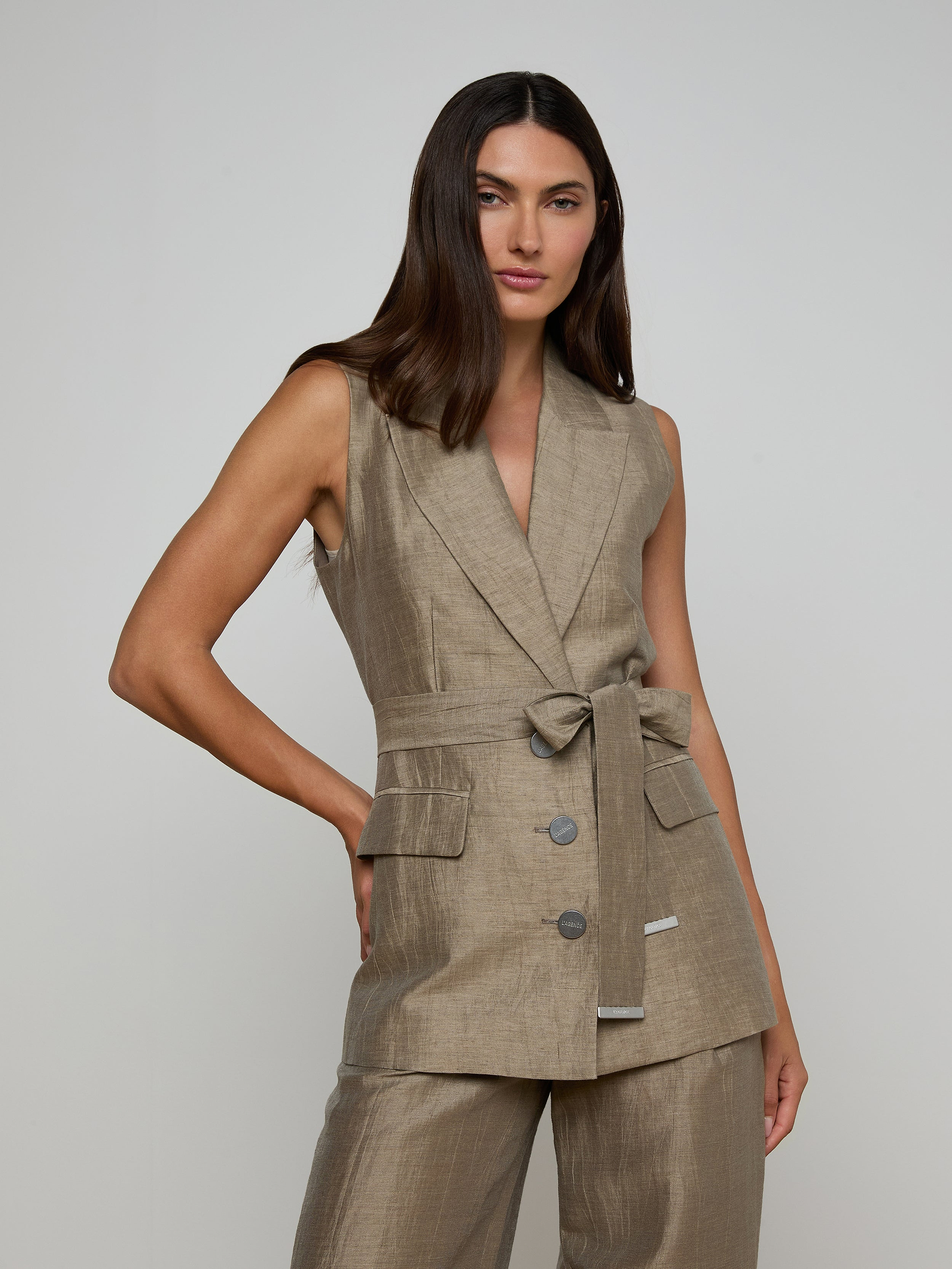 A woman with long dark hair wears the Harper Linen-Blend Vest with matching pants, standing against a plain light background.
