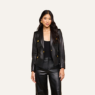 A woman stands facing forward, wearing the Wisteria Leather Blazer with gold buttons and matching black leather pants against a plain light background.