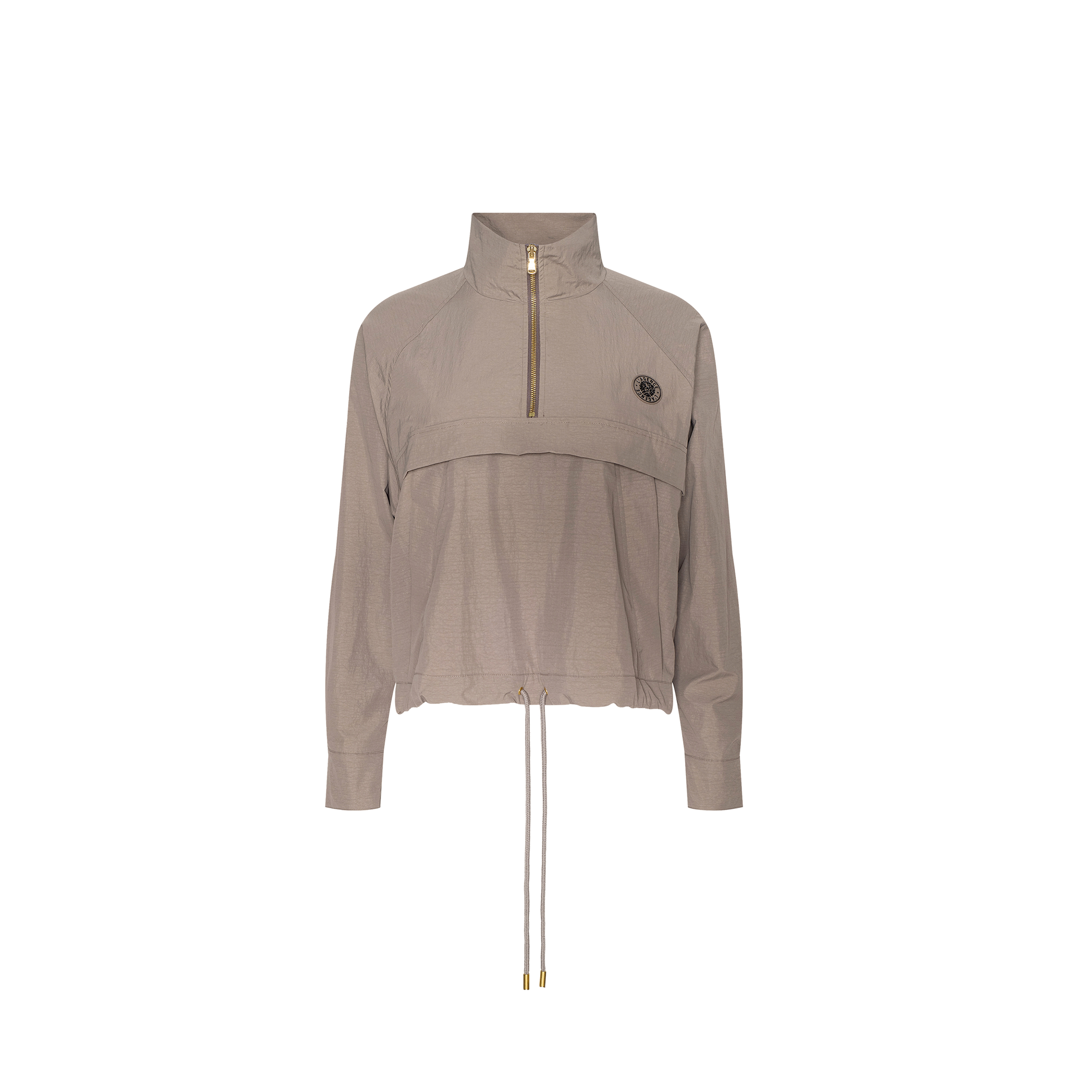 Vex Cropped Windbreaker in light brown, featuring long sleeves, a half-zip front, high collar, drawstring hem, and a small round emblem on the left chest, displayed on a plain white background.